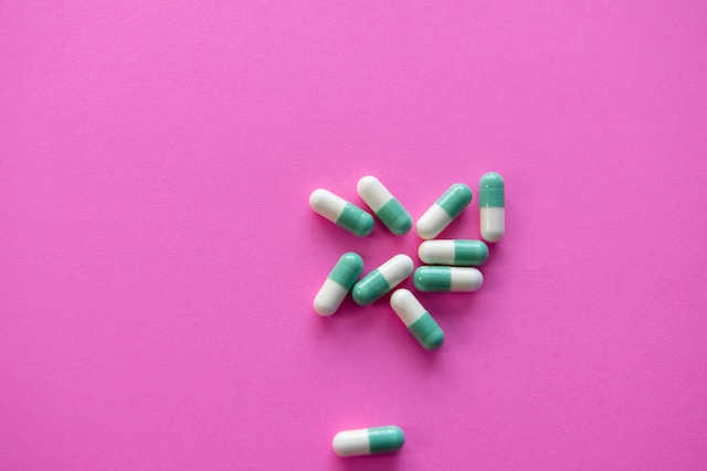 Niebiesko-białe tabletki na różowym tle
